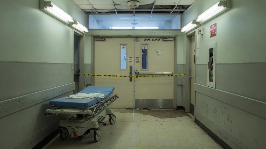 A hospital corridor with closed fire doors and an empty gurney